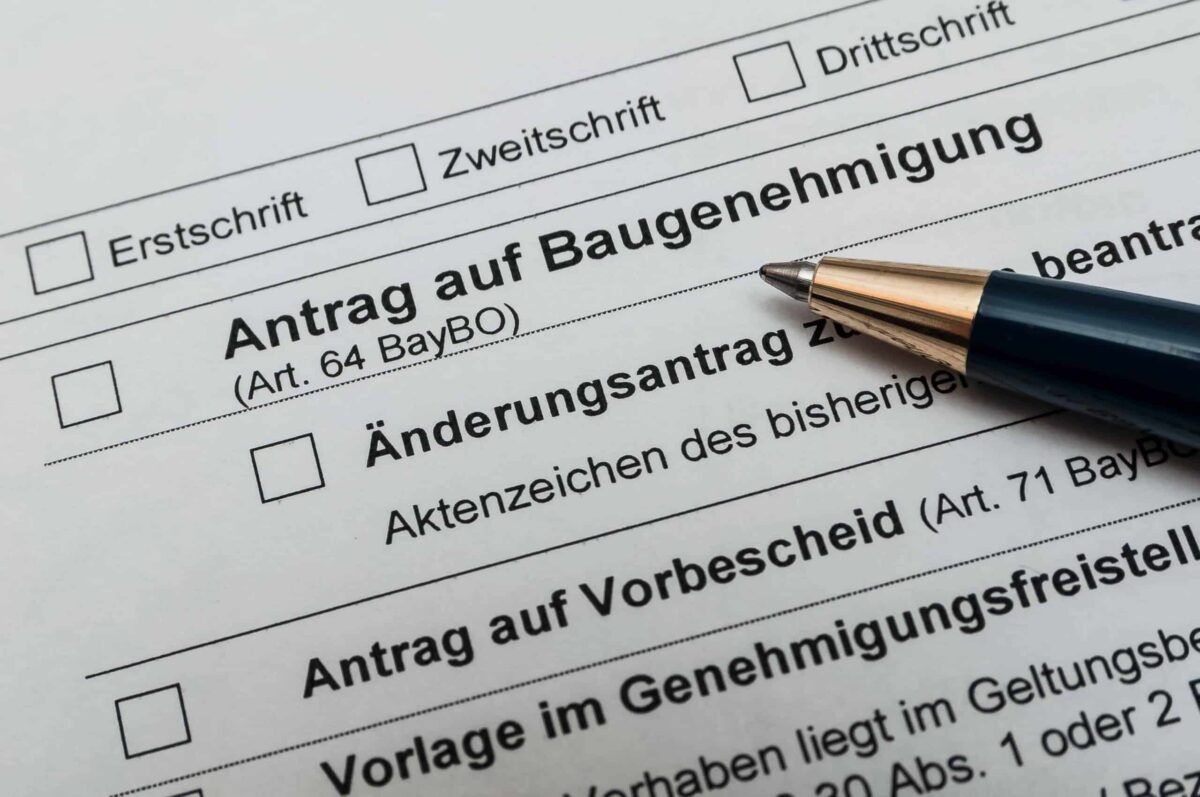 Formular für Antrag auf Baugenehmigung mit Kugelschreiber – Symbol für Genehmigung beim Bau eines Hundezwingers
